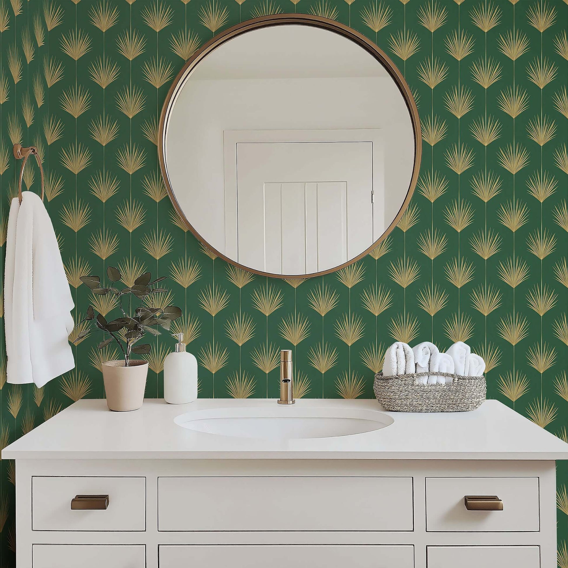 Bathroom with Art Deco gold palm leaf wallpaper on green background, featuring round mirror and white vanity.