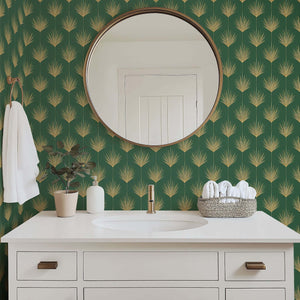 Bathroom with Art Deco gold palm leaf wallpaper on green background, featuring round mirror and white vanity.