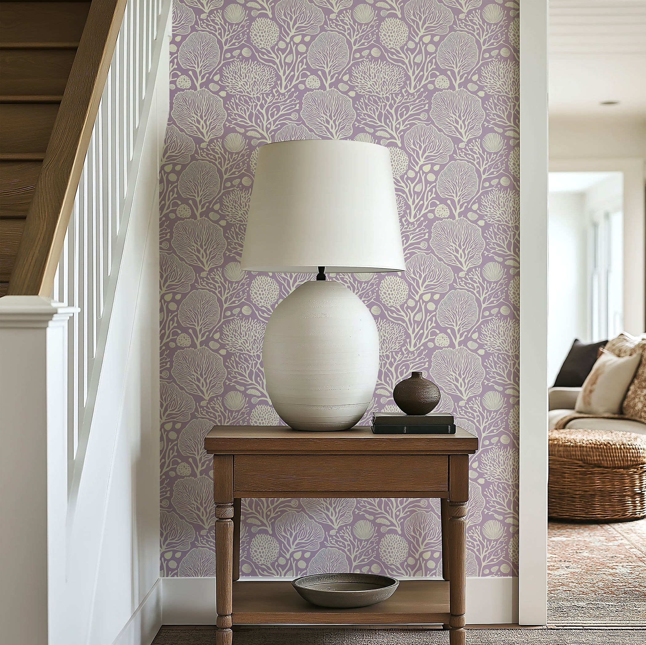 Lavender Coral Oasis wallpaper featuring coral and seashell patterns in a coastal-themed interior setting with a table and lamp.