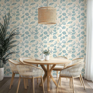 Beachcomber wallpaper featuring hand-drawn seashells and starfish in ocean blues, creating a coastal ambiance in a dining room.