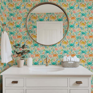 Bathroom with "Crab Cove" coastal wallpaper featuring watercolor crabs, coral, and ocean plants in vibrant blue and citrus hues.