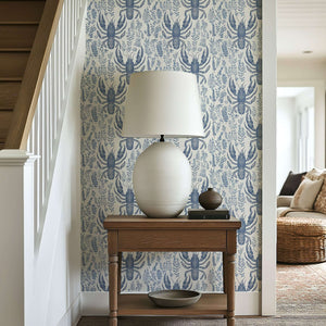 Coastal-themed Lobster Bay wallpaper with navy lobsters and botanical design on ivory background, enhancing a seaside home interior.