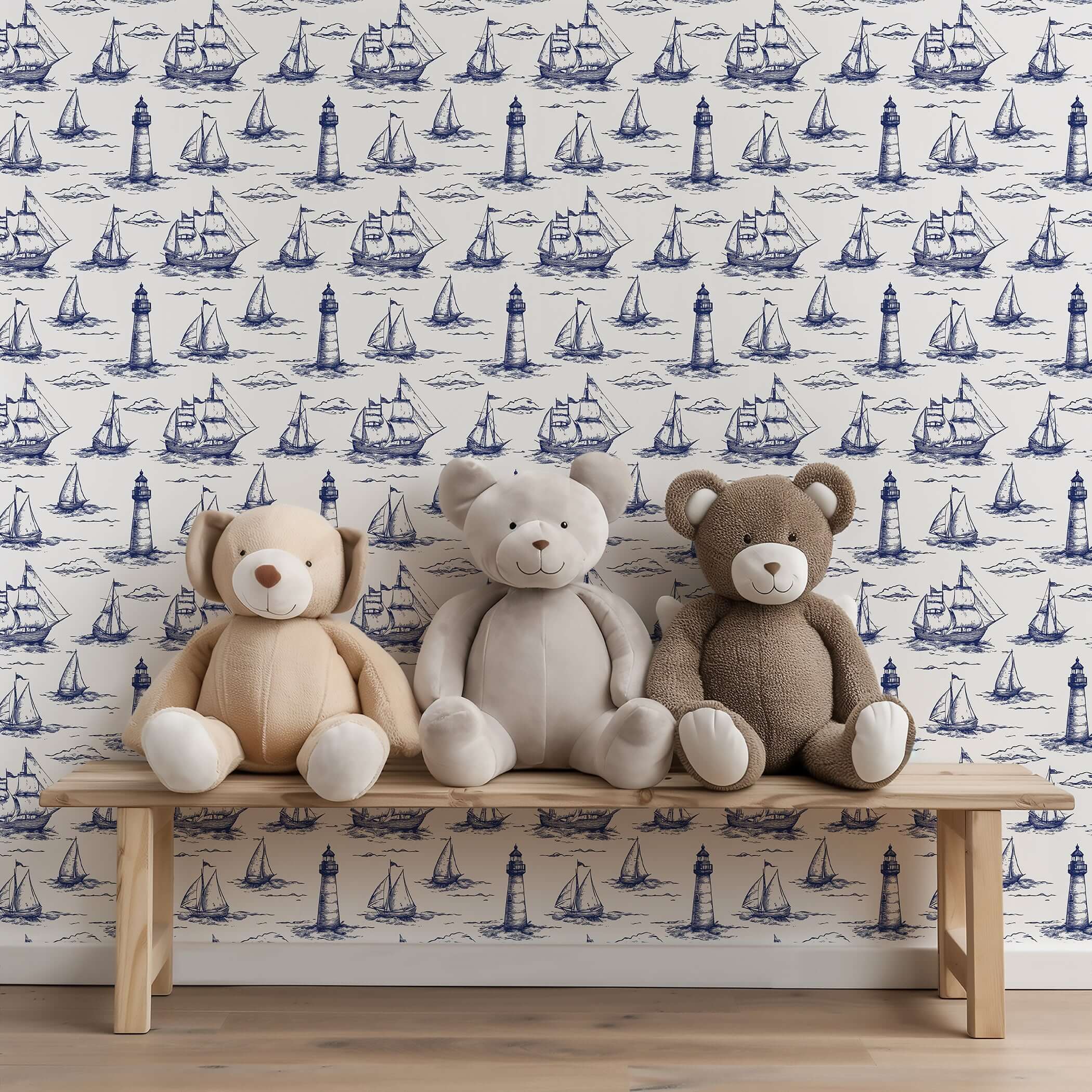 Beacon Bay coastal wallpaper with navy sailboat and lighthouse pattern, complemented by three teddy bears on a wooden bench.