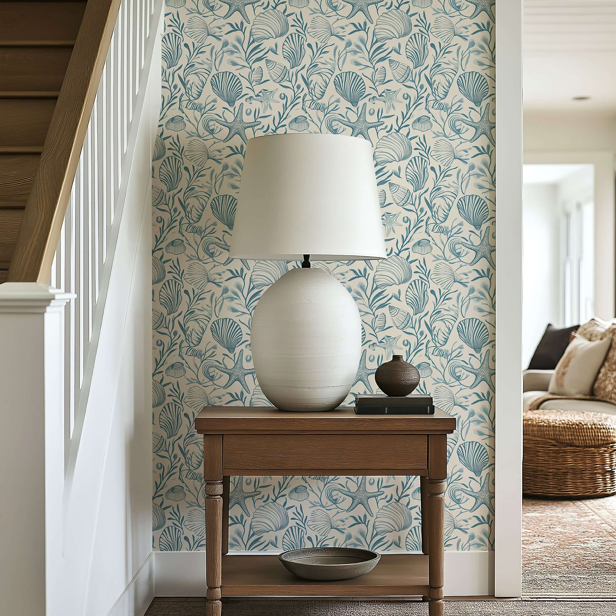 "Seashell Harmony" wallpaper with seashells, starfish, and sea grass adds coastal elegance to a living space, featuring a table lamp.