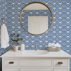 Crab Royale Damask wallpaper in blue with white crabs and seaweed florals, creating a coastal elegance in a bathroom setting.