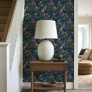 Enchanted Ocean Flora wallpaper featuring vivid ocean plants in violet, coral, emerald, and gold on a navy backdrop.