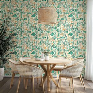 Coastal wallpaper featuring fish, coral, and seaweed in teal and sandy hues for a mid-century-modern dining room.