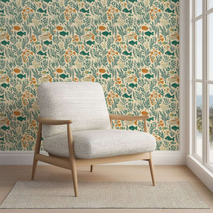 Mid-century modern chair against coastal wallpaper with fish, coral, and seaweed in teal and green hues.