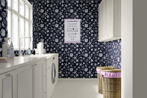 Laundry room with coastal wallpaper featuring white starfish and seashells on a navy background, enhancing beach-themed decor.