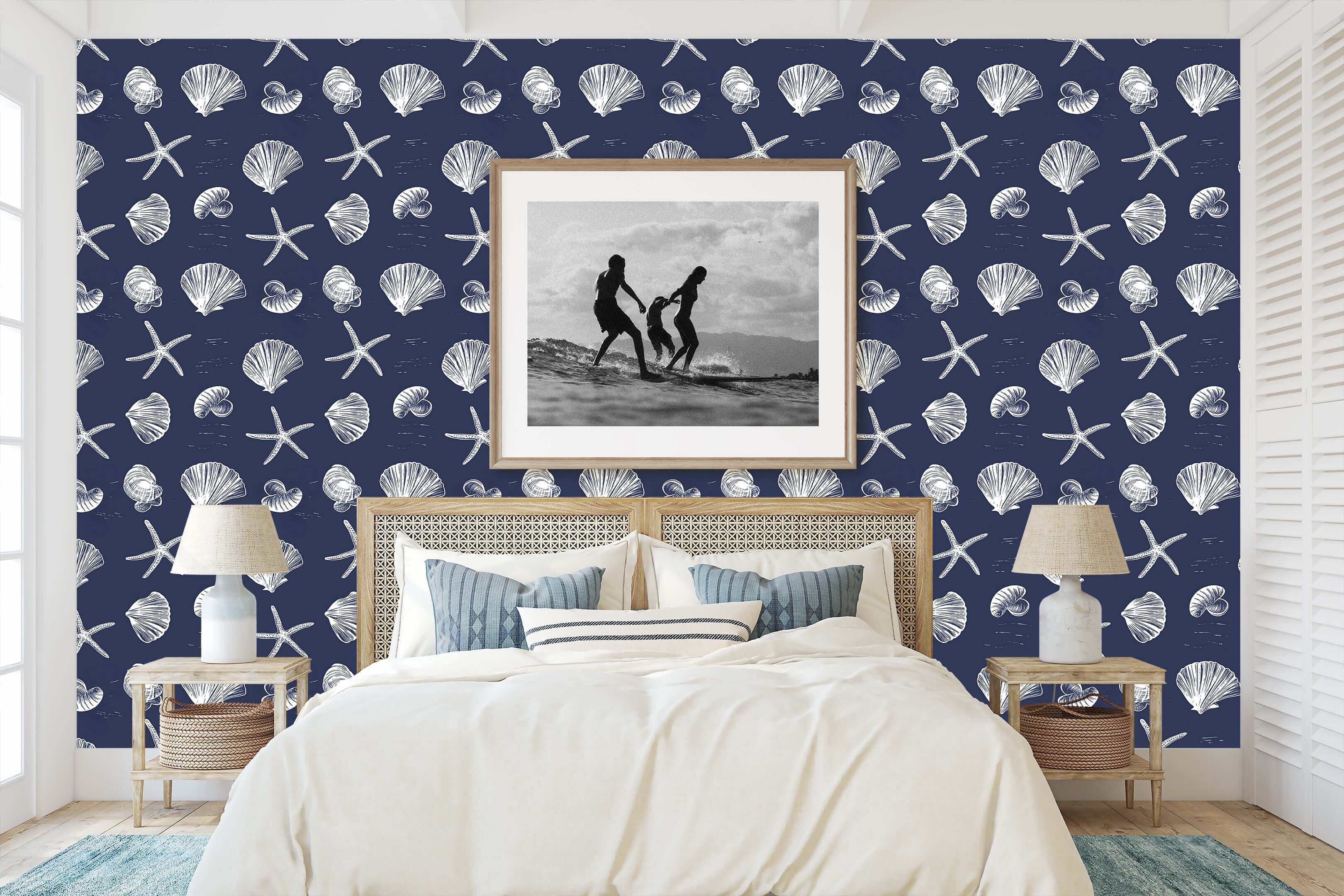 Bedroom with Coastal Inked Classics wallpaper featuring starfish and seashells on a navy background, enhancing a beach-themed decor.