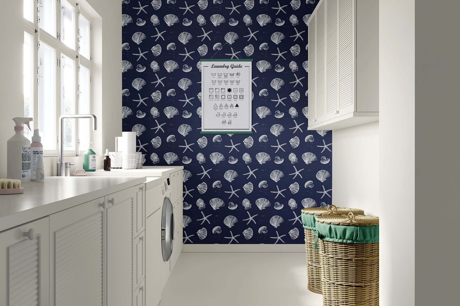 Coastal Inked Classics Wallpaper with starfish and seashells on a navy background in a bright coastal-themed laundry room.