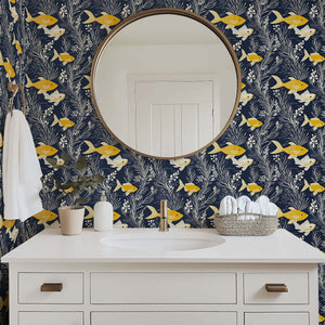 Ocean-themed coastal wallpaper with golden yellow fish and white seaweed on navy blue, perfect for beach house bathrooms.