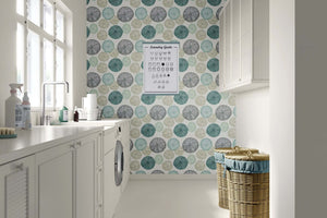 Modern sea urchins wallpaper in teal, sage, and gray accents a contemporary laundry room, showcasing coastal and beach design elements.