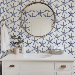 Bathroom with Seaside Stars wallpaper featuring blue starfish on white for a modern coastal beach design.