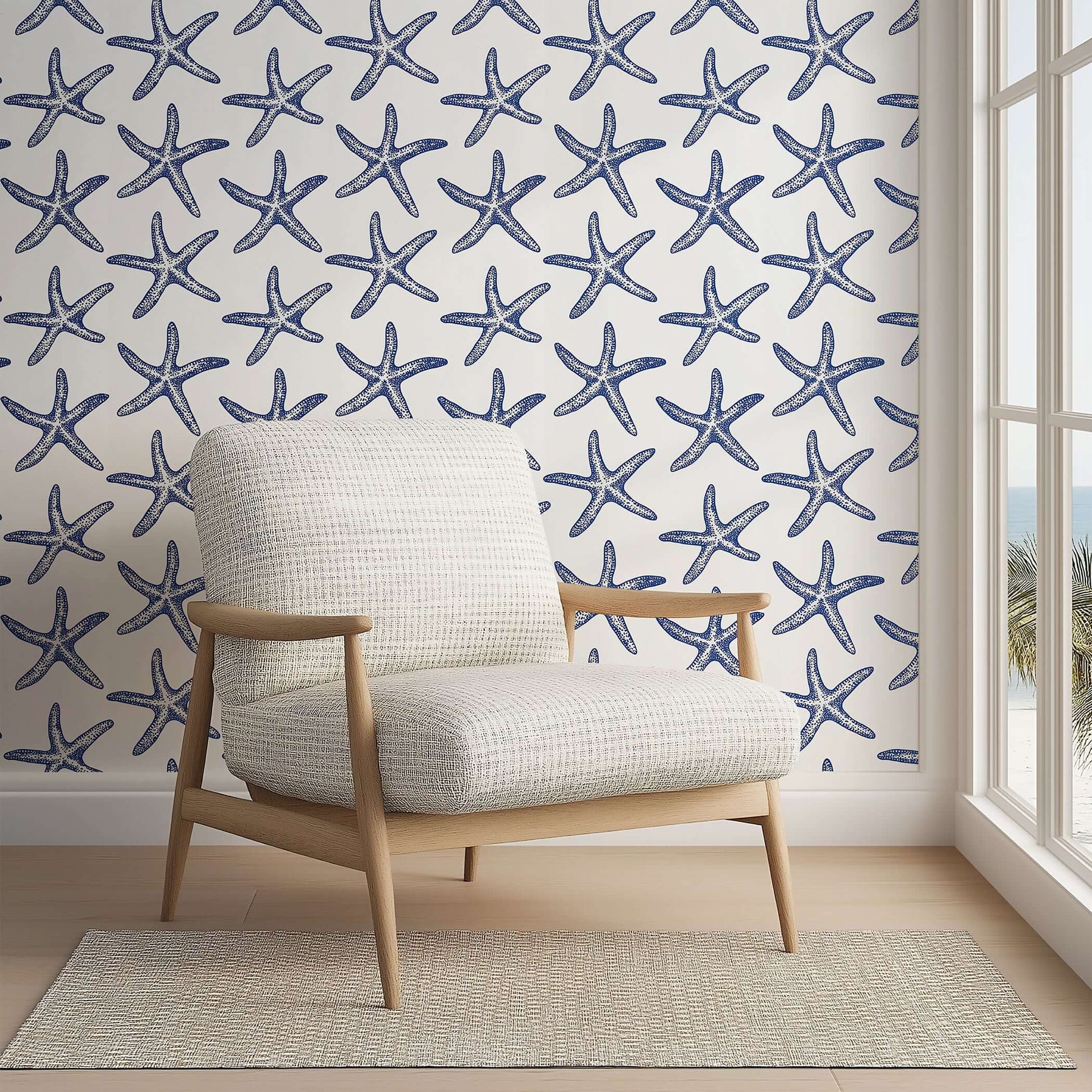Modern coastal wallpaper featuring blue starfish on white background, perfect for beach-themed decor in bedrooms and living spaces.