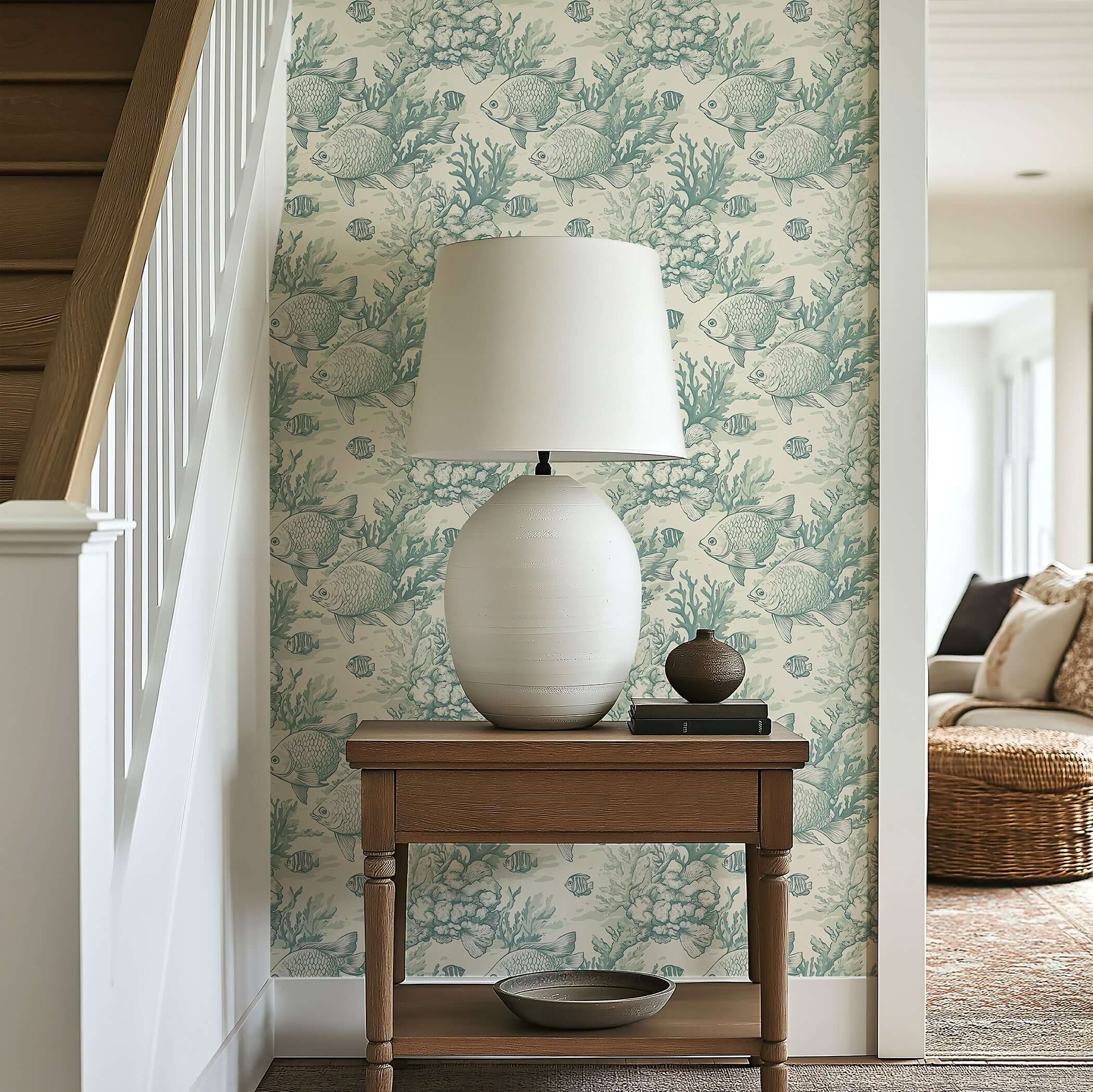 Coastal wallpaper with hand-drawn fish and coral in seafoam tones enhances a nautical-themed interior near a wooden table and lamp.