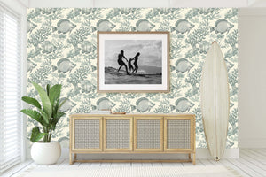 Elegant coastal wallpaper with vintage fish design enhancing a beach-themed room, featuring surfboard and framed picture.
