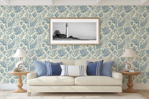 Coastal living room with Marine Retreat wallpaper featuring ocean-inspired coral designs in blue on ivory background, modern coastal decor.