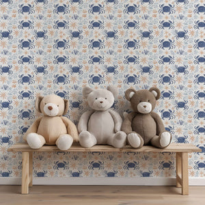 Coastal Crawlers wallpaper with blue crabs and starfish behind a bench of plush teddy bears, ideal for ocean-themed decor.