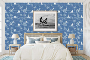 Coastal bedroom with Sail and Palm wallpaper featuring toile design of sailboats and palm trees on a blue backdrop, ideal for beach decor.