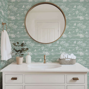 Palm Coastline wallpaper featuring palm trees and sailboats in a coastal bathroom setting with a round mirror and white vanity.