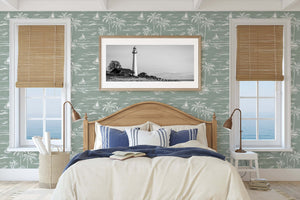 Bedroom with Palm Coastline wallpaper featuring boats, palm trees, and coastal view in sage green and white, enhancing coastal decor.