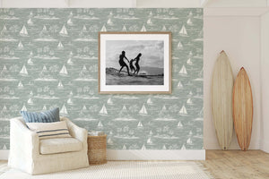 Harbor Calm wallpaper with sailboats and palm trees in coastal room featuring surfboards and armchair, ideal for nautical decor.