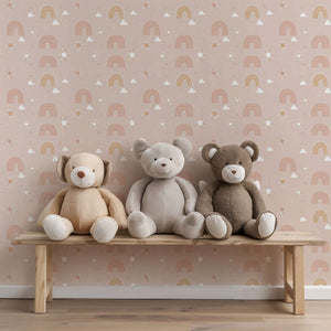 Three plush bears sit on a bench against pink Dreamy Rainbows wallpaper, perfect for modern nurseries and playrooms.