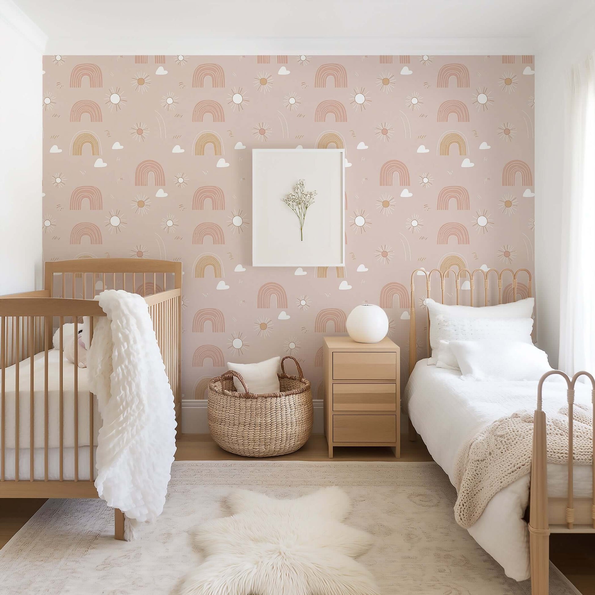 Cozy nursery with Dreamy Rainbows wallpaper featuring pink and earth-toned rainbows, suns, and clouds for a modern, playful vibe.