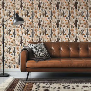 Rustic Desert Blooms wallpaper with cacti in earthy tones, featuring French toile design behind a leather couch and lamp in living room.