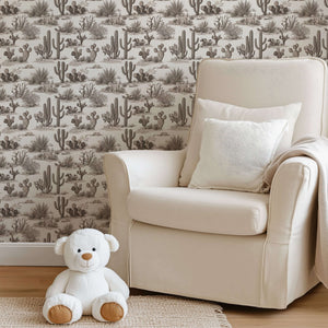 Desert Toile Elegance Wallpaper with hand-drawn cacti and succulents in a neutral palette, enhancing a cozy living room corner.
