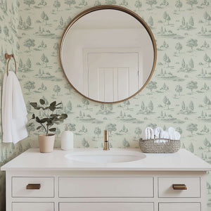 Bathroom with mirror reflecting serene green toile landscape wallpaper featuring woodlands and streams by Wall Artifacts.