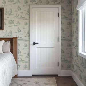 Bedroom with Lush Pastoral Toile II Wallpaper featuring green French toile landscape on pale walls behind a white door.