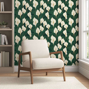 Opulent Calla Lilies wallpaper featuring ivory and gold lilies with a modern design on a deep green background behind an armchair.