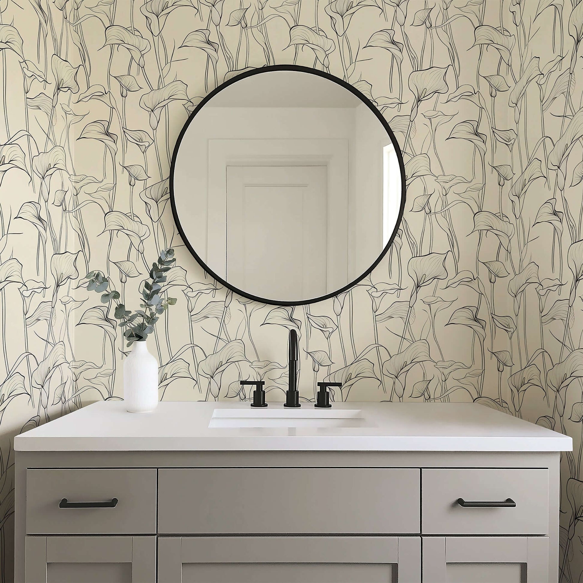 Monochrome calla lily wallpaper in a modern bathroom with round mirror, sleek sink, and minimalist design elements.