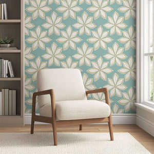 Mid-century modern wallpaper with white flowers on teal, adding retro flair to a room with a beige armchair.