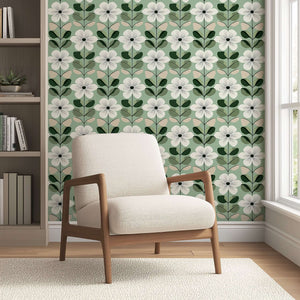 Mid-century modern wallpaper with white flowers and green leaves on sage backdrop, enhancing a cozy living room with an armchair.