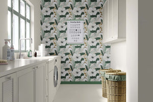 Golden Greenscape wallpaper with white blossoms, lush green foliage, and gold accents in a contemporary laundry room setting.