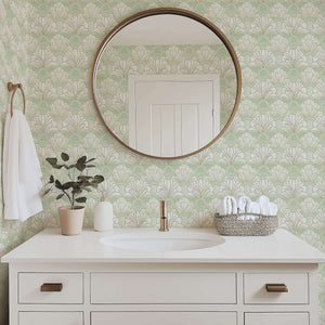 Mint green and white floral art deco wallpaper with fan-shaped design in a modern bathroom, featuring a round mirror and elegant decor.