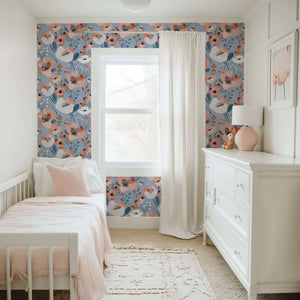 Modern nursery with Blue Breeze Blossom wallpaper featuring whimsical coral, ivory, navy floral patterns on a soothing blue background.