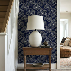 Island Nights Floral Wallpaper with hibiscus flowers on a navy background, creating a tropical coastal vibe in a home decor setting.