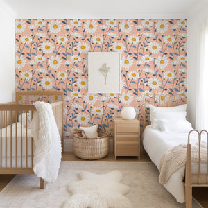 Sunshine Floral Meadow wallpaper with white daisies and soft blue foliage on a peach background in bedroom, featuring modern floral design.