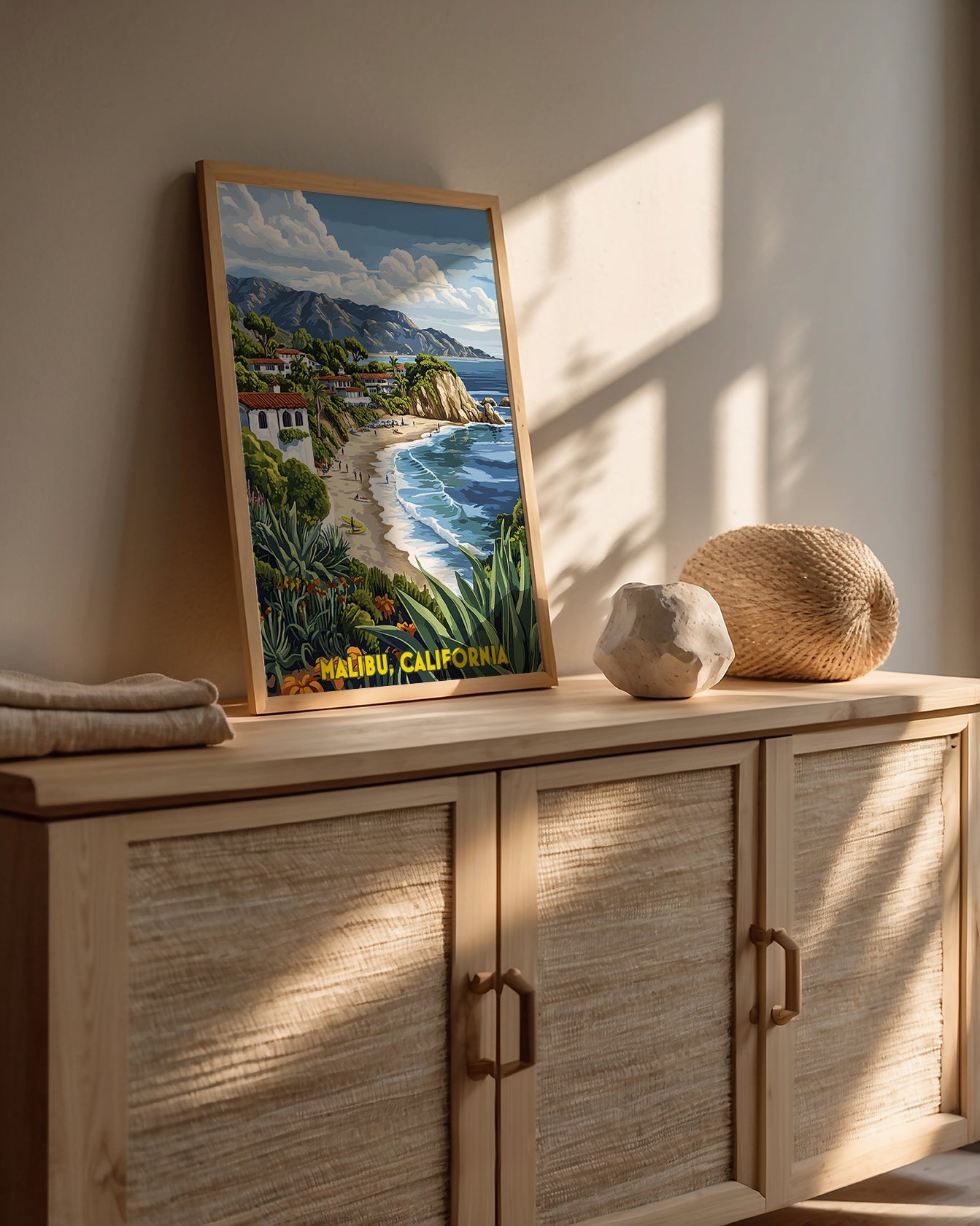 Malibu, California vintage travel poster artwork on a stylish wooden cabinet, showcasing a beach landscape with ocean waves.