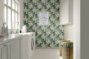 Elegant retro floral wallpaper with ivory blossoms, sage leaves, on a soft teal background in a modern laundry room.