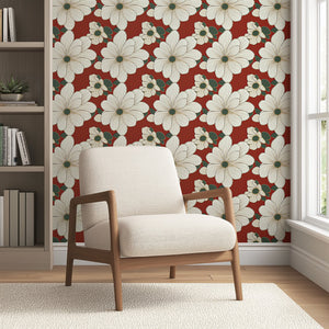 Elegant white floral wallpaper with gold outlines on a red background, featuring green foliage, lining a cozy living room corner.