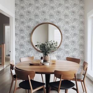 Monochrome floral wallpaper in a dining room setting with a round mirror and wooden table, featuring chrysanthemum patterns in black and white.