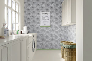 Elegant laundry room with black and white floral wallpaper featuring chrysanthemums, enhancing the monochromatic, minimalist design.