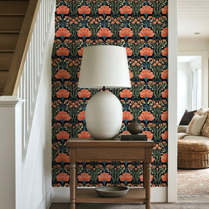 Decorative wall with Vivid Garden Bloom floral wallpaper featuring coral and salmon flowers on a black background, alongside a lamp on a wooden table.
