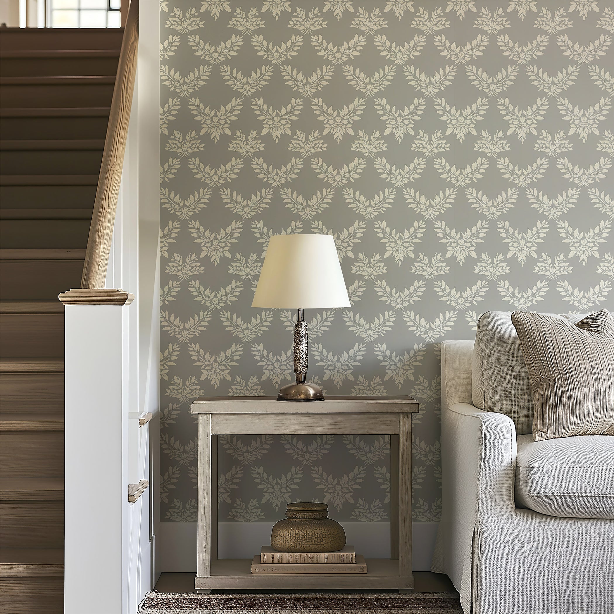 Gray wallpaper with ivory laurel wreath patterns, complementing modern and traditional decor, adds elegance to living spaces.