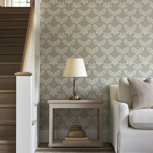 Gray wallpaper with ivory laurel wreath patterns, complementing modern and traditional decor, adds elegance to living spaces.